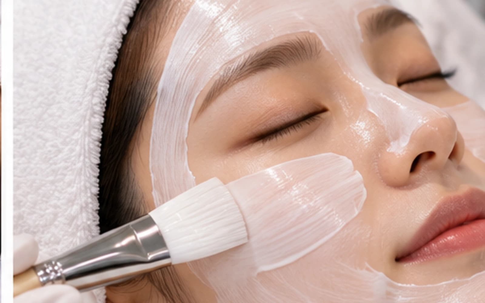 Hydrating facial mask being applied during a Korean skin care treatment